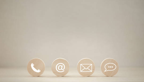 istock closeup phone, address, mail, chat icon on round wooden piece 1427906465
