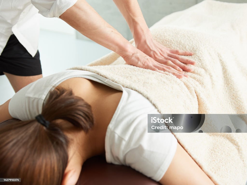 Mujer japonesa recibiendo un masaje de cintura - Foto de stock de Dar masajes libre de derechos Mujer japonesa recibiendo un masaje de cintura - Foto de stock de Dar masajes libre de derechos