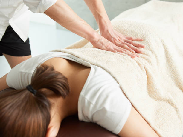mujer japonesa recibiendo un masaje de cintura - backache chiropractic adjustment pain women fotografías e imágenes de stock