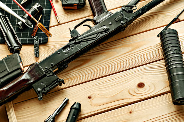 istock Black disassembled shotgun and cleaning tools on wooden table . 1427911192