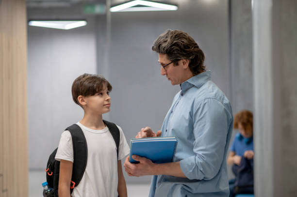 istock Teacher explaining something to a schoolboy at the recess 1427911429