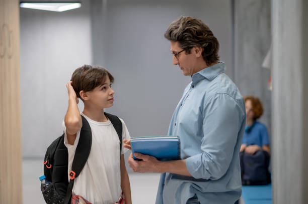 istock Inquisitive pupil communicating with the teacher in the corridor 1427911439