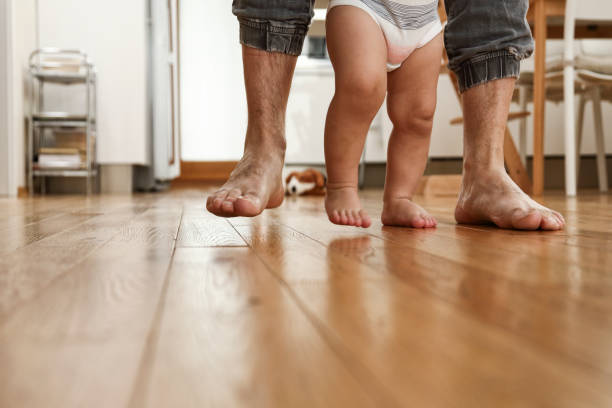istock Father teaching baby to walk 1427913471