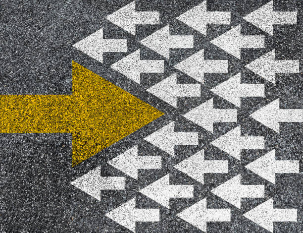 istock Different thinking and Business and technology disruption concept. Yellow big arrow opposite direction with white arrow on road asphalt. 1427917725