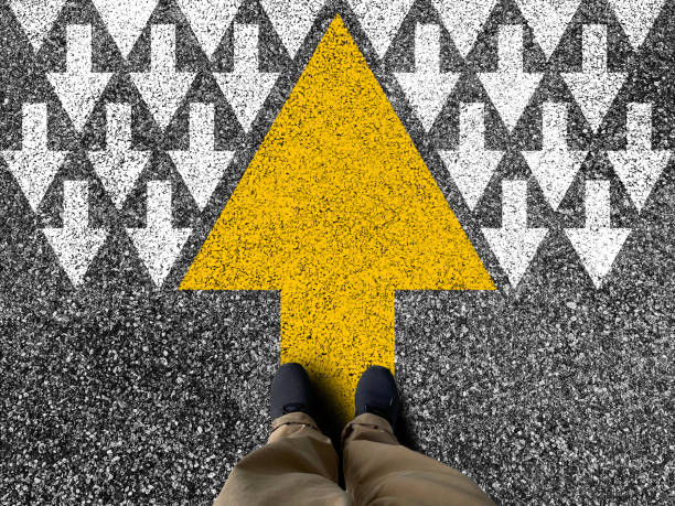 Different thinking and Business and technology disruption concept. Yellow big arrow opposite direction with white arrow on road asphalt.