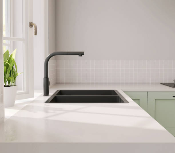 istock Minimal and contemporary green kitchen counter with white laminated plastic top and black quartz sink with sunlight from window on wall 1427920218