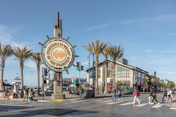 people enjoy Fisherman's Wharf in San Francisco, in dawn. Famous illuminated signage shows fishermens wharf stock photo