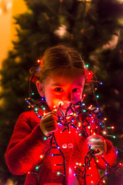 istock Girl playing with Christmas lights. 1427921951