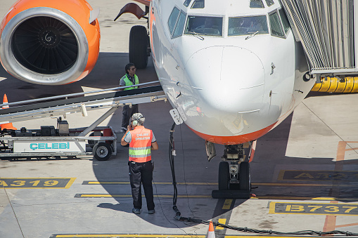 20 July 2022, Antalya, Turkey: Ground service workers providing inspection and technical maintainance of airplane before departure and boarding of passengers