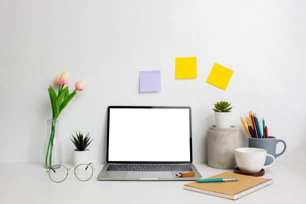 istock Working space with flowers, candle, coffee cup and books over the white table. 1427927294
