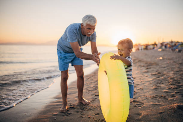 istock Grandfather and grandson playing with inflatable ring on the beach 1427930191