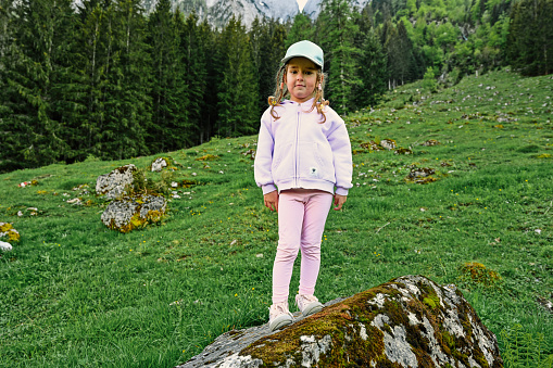 Baby girl stand in stone at Vorderer Gosausee mountains, Gosau, Upper Austria.