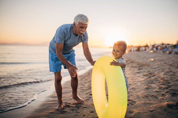 istock Grandfather and grandson playing with inflatable ring on the beach 1427930840