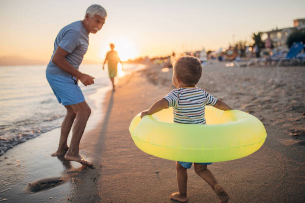 istock Grandfather and grandson playing with inflatable ring on the beach 1427933502