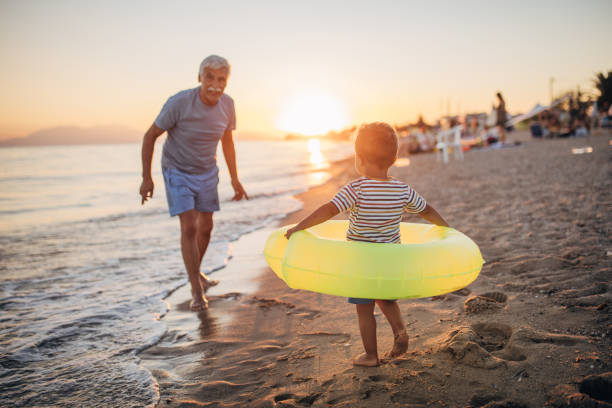 istock Grandfather and grandson playing with inflatable ring on the beach 1427933690