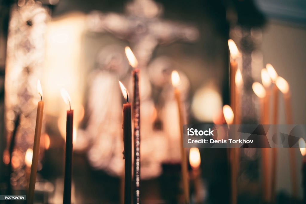 church candles close-up, against the background of a specially blurred religious cross Church Stock Photo