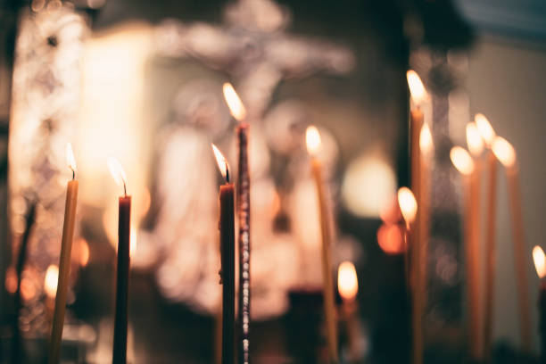 church candles close-up, against the background of a specially blurred religious cross - candlestick holder fotos imagens e fotografias de stock