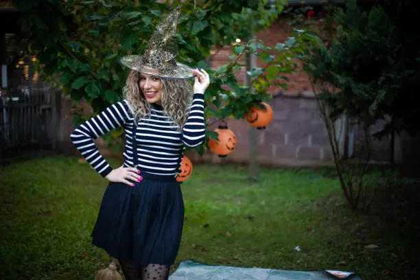 Photo of The woman is dressed as a witch. She celebrates Halloween.