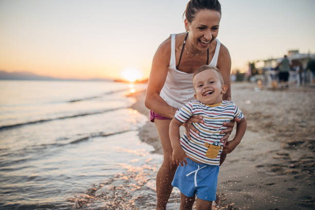 istock Mother and son chasing on the beach 1427937561