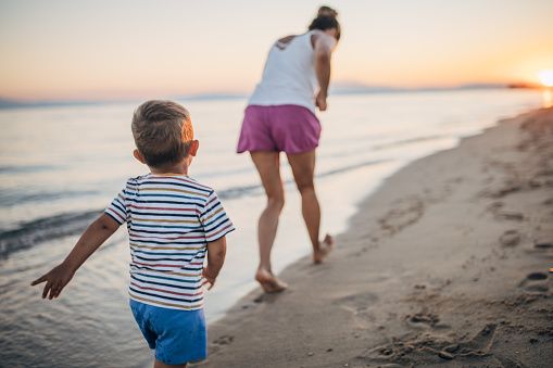 Mother and son chasing on the beach