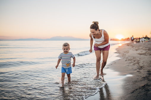Mother and son chasing on the beach