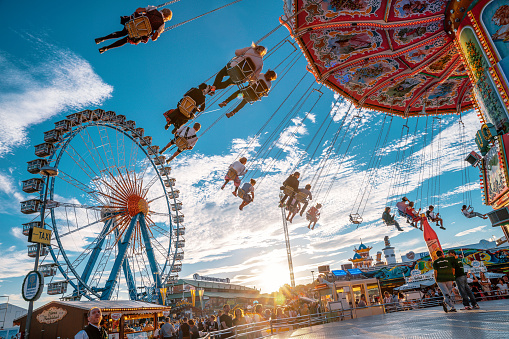 High up in the sky, people ride a carousel in an amusement park