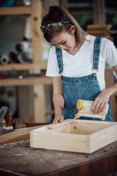 istock happy attractive hardworking middle aged professional female carpenter worker looking and choosing wood in the workshop. 1427951114