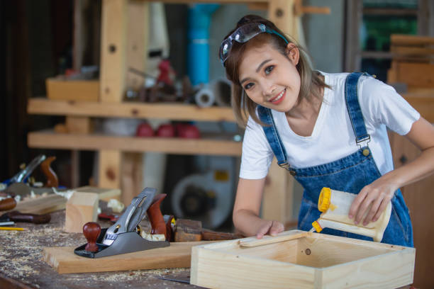 istock happy attractive hardworking middle aged professional female carpenter worker looking and choosing wood in the workshop. 1427951117