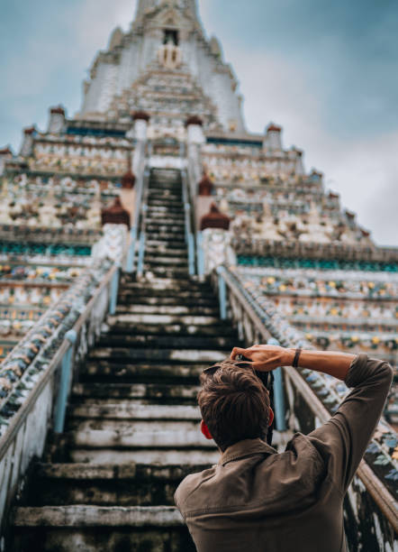 Close-up of a young man exploring  Wat Arun, Buddhist temple in Bangkok, Thailand