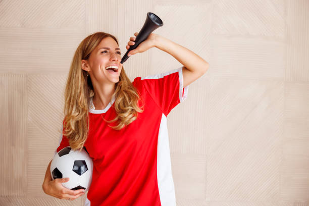 Female football fan cheering while watching the game