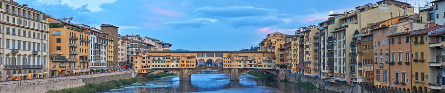 Florence, Italy - September 07, 2022: Crowd of people at the Ponte Vecchio bridge, the landmark of Florence, at sunset.