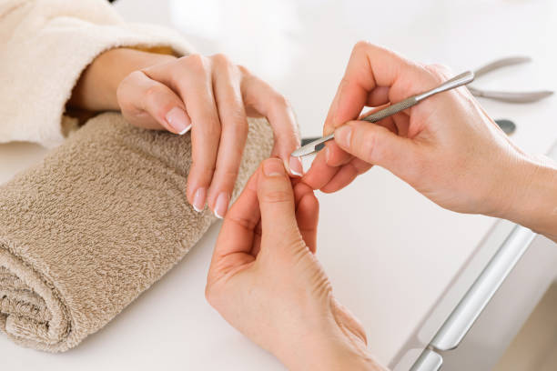 Manicurist tending nails of female client stock photo