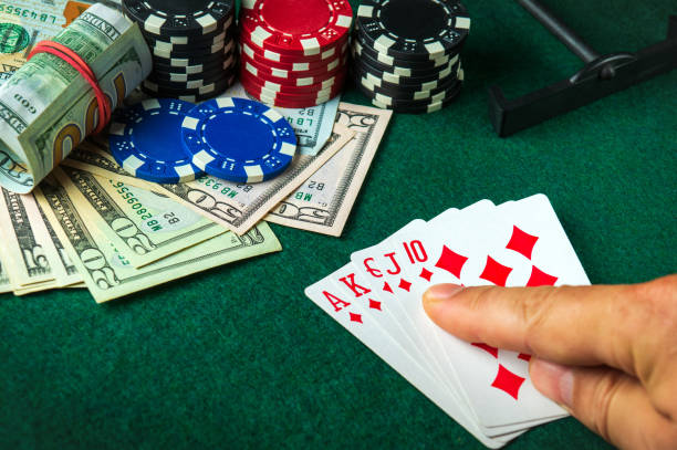 istock The player points with his finger at a winning Royal Flush combination in a poker game on a table with chips and money in a casino 1427959675