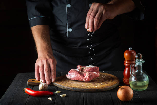 istock The chef sprinkles the meat with salt. Preparing meat before baking. Working environment in restaurant kitchen. 1427959791