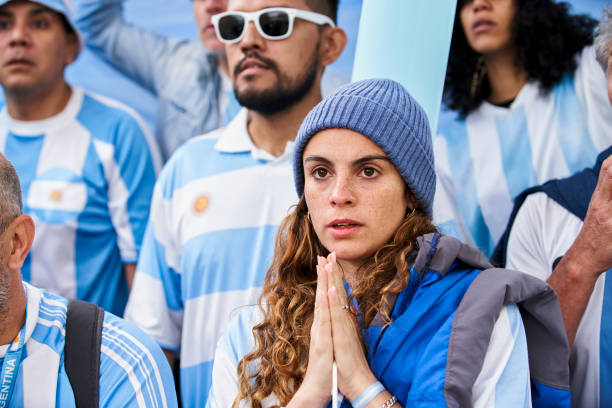 Nervous Argentinian female football fan watching match stock photo