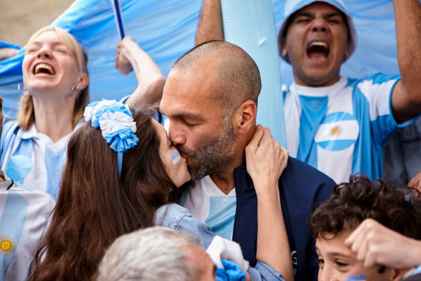 Argentinian couple celebrating football score while kissing stock photo