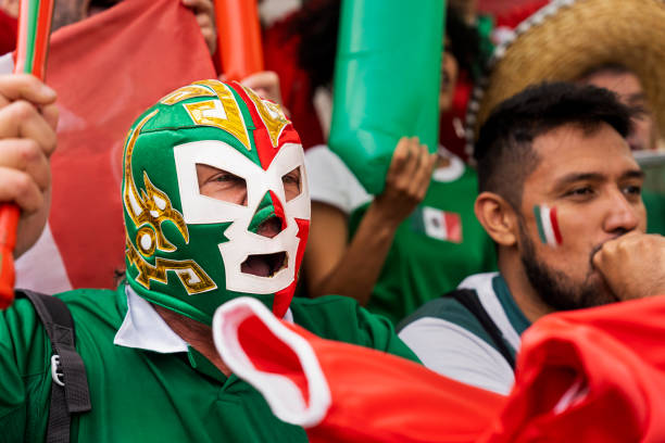 Mexican football fan wearing lucha libre mask while watching match at stadium stock photo