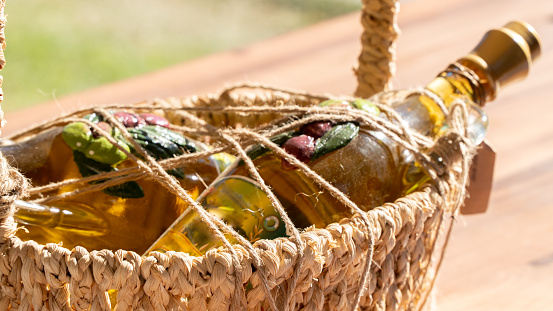 Olive oil in a glass bottle in a braided straw basket
