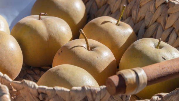 maçãs amarelas em uma cesta trançada de close-up, fundo de frutas - agriculture autumn apple greengrocers shop - fotografias e filmes do acervo