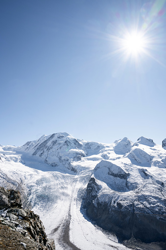 wide panoramic view on Gorner Glacier against blue sky in the backlit of autumn sun