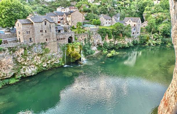 la comuna de saint-chély du tarn y la cascada que desemboca en el río tarn. - hollow fotografías e imágenes de stock