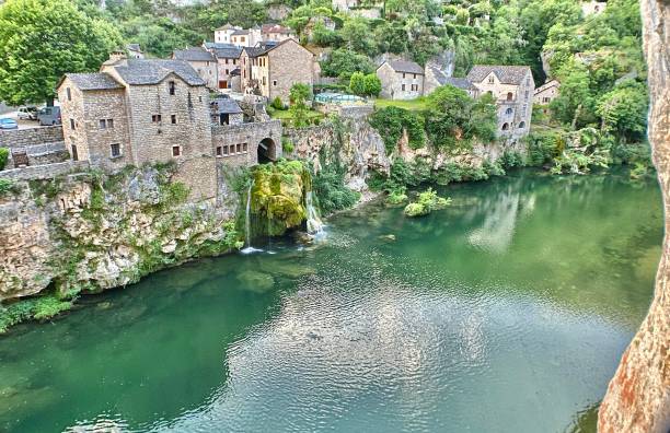 the commune of saint-chély du tarn and the waterfall emptying into the river tarn. touring southern france and the tarn river valley - june 2022. samuel howell stock pictures, royalty-free photos & images