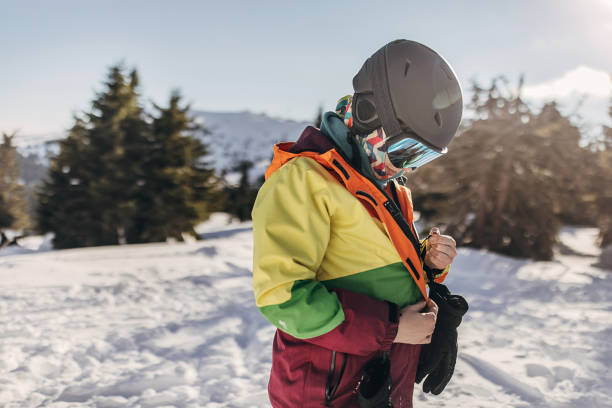 One woman, female skier standing on a hill on a snowcapped mountain.
