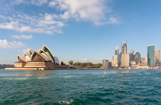 Sydney Australia - August 5, 2019: A clear afternoon in Sydney, New South Wales, and this is the view looking across Sydney Harbour towards the iconic shape of the city's Opera House.