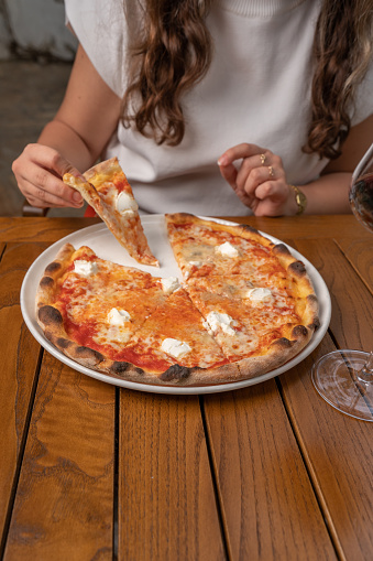 Woman eating pizza. Holding pizza slice
