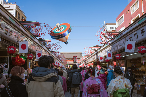 Tokyo, Japan - January 2, 2021: People walking on Nakamise-dori Shopping Street with new year decoration that starts at Kaminarimon Gate and leads to Sensoji Temple in Asakusa District.