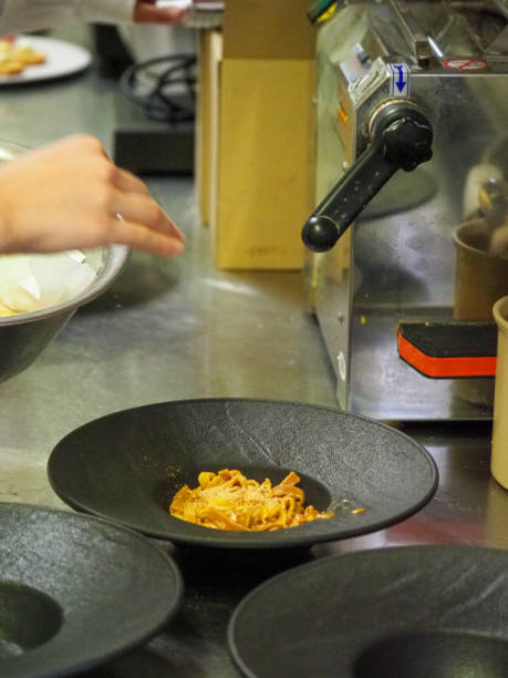 istock chef plating tagliatelle sauce pasta into black design dishes - mise en place 1427967919