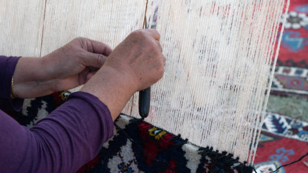 istock Women's hands knit carpet on a loom, textile industry 1427967949