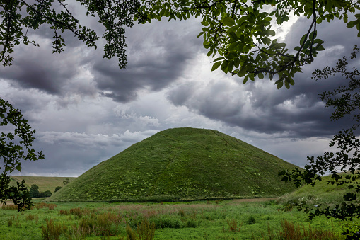 silbury hill near avebury wiltshire seen through a frame of trees