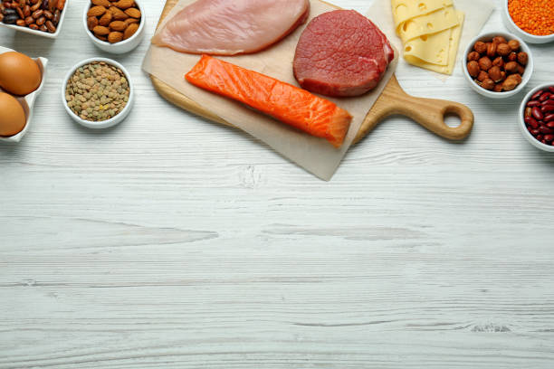 istock Different fresh products on white wooden table, flat lay and space for text. Sources of essential amino acids 1427974127